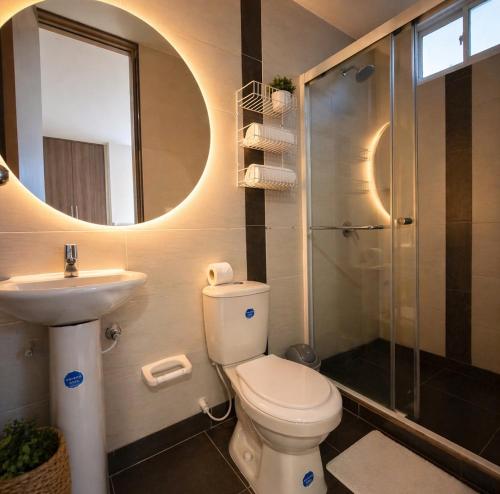 a bathroom with a toilet and a sink and a shower at Hotel Sun Suite in Barranquilla