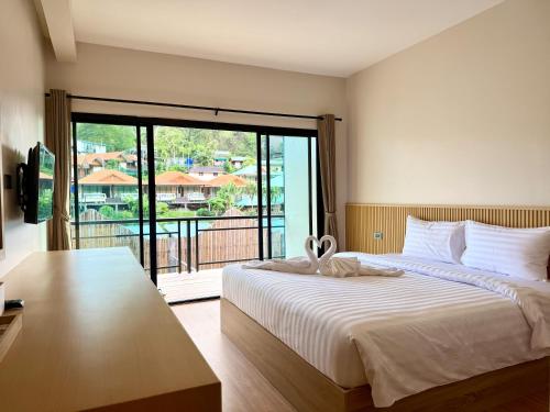 a bedroom with a large bed and a large window at Phi Phi Vista Nest Resort in Phi Phi Islands