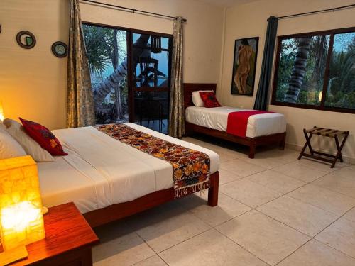 ein Schlafzimmer mit zwei Betten und einem Fenster in der Unterkunft El Roble Nature Hotel & Lagoon in Bacalar