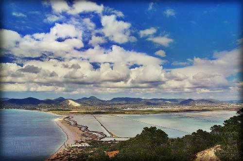 a view of a beach with mountains and the ocean at All Suite Ibiza Aparthotel in San Antonio