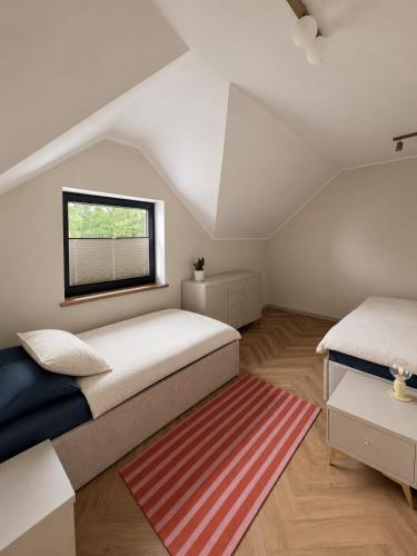 a bedroom with two beds and a window at Pod Skrzydłami II in Liksajny