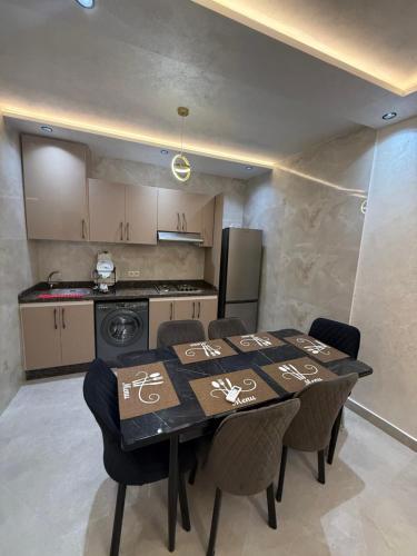a dining room table with chairs and a kitchen at اقامة هبة 1 in Yebha