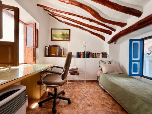 a room with a desk and a chair and a bed at casa rural excentrico alcala in Vélez de Benaudalla