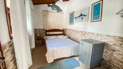 a small bedroom with a bed and a trash can at Pousada Mercador in Paraty