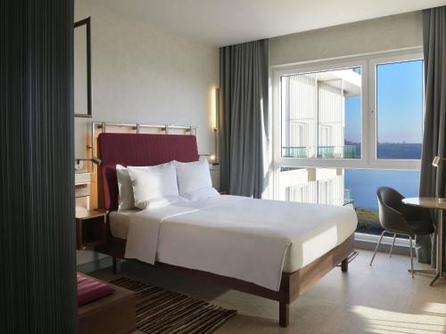 a hotel room with a bed and a large window at Novotel Lubumbashi in Lubumbashi