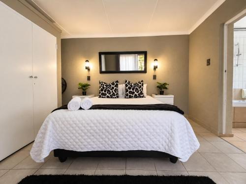 a bedroom with a large bed and a mirror at Zhantique Guest House 2- Unit 3 in Boksburg