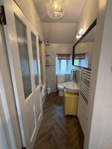 a bathroom with a sink and a toilet in it at Snowdrop Cottage in Orkney