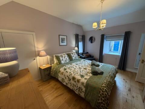 a bedroom with a teddy bear sitting on a bed at Snowdrop Cottage in Orkney