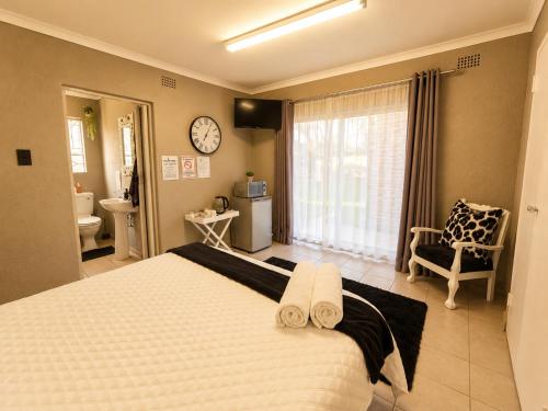 a bedroom with a large bed with a clock on the wall at Zhantique Guest House 2- Unit 3 in Boksburg