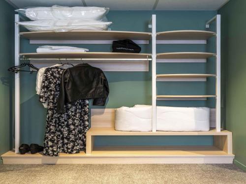 a closet with wooden shelves and white towels at ibis Styles Limoges Centre in Limoges