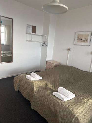 a bedroom with a bed with two towels on it at carlsens hotel in Vesterø Havn