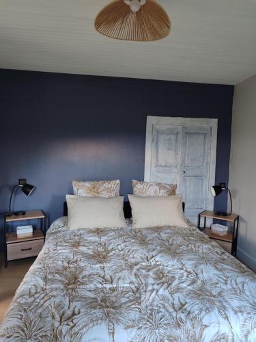 a bedroom with a large bed with a blue wall at Maisonnette de vignes avec vue imprenable in Marvejols