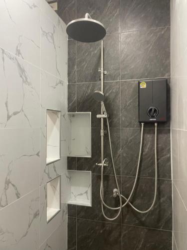 a bathroom with a shower with a hose in it at J House Has love in Sukhothai