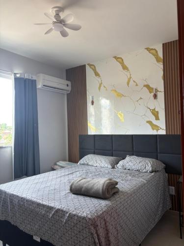 a bedroom with a bed with a blanket on it at Apartamento Com Piscina prox a BR in Ananindeua