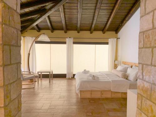 a bedroom with a large bed and a large window at Il Giardino del Belvedere in Barrafranca