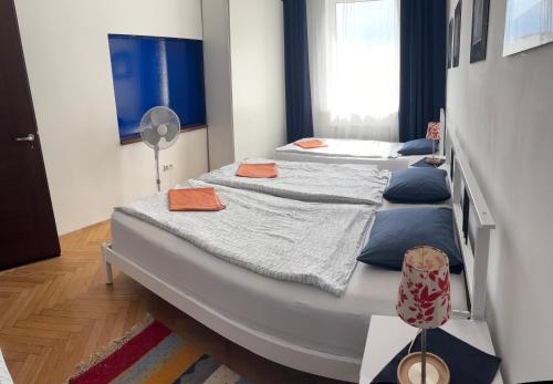 two beds in a room with blue and white at Apartment Maximilian in Bratislava