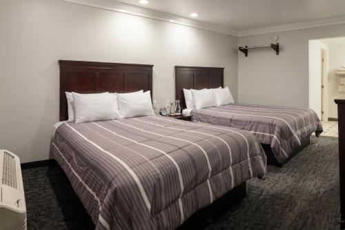 a hotel room with two beds with striped sheets at Capital City Inn Sacramento Convention Center CA in Sacramento