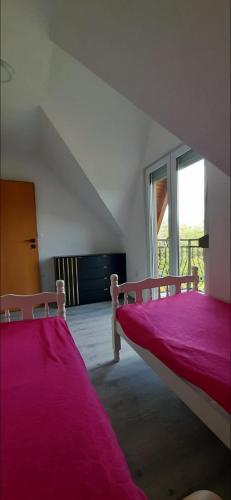 a bedroom with two beds with pink sheets at Vikendica Sana in Sanski most