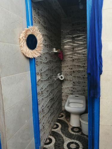 a bathroom with a toilet and a blue door at Grotte de pêcheurs Tigri in Aglou