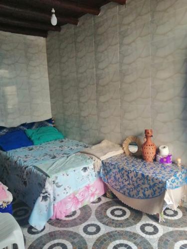 a bedroom with a bed and a table with vases on it at Grotte de pêcheurs Tigri in Aglou