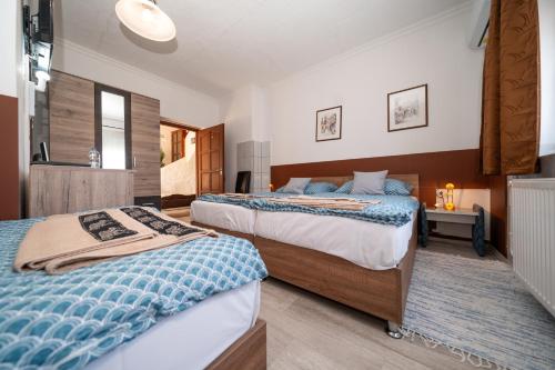 a bedroom with two beds and a bathroom at Varga Vendégház in Tótszerdahely