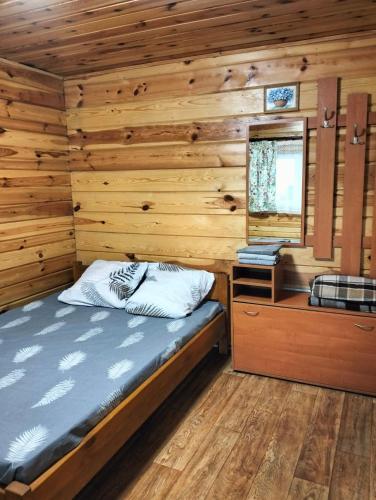 a bedroom with a bed in a log cabin at Krainya hata in Melʼniki