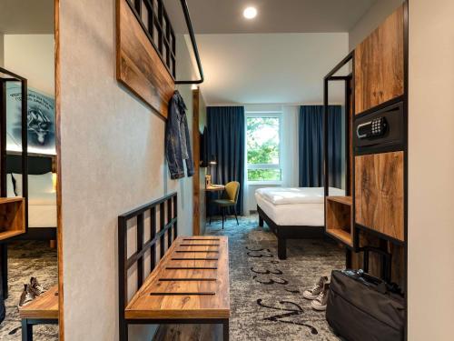 a hotel room with a bedroom with a bed and a desk at ibis Styles Hamburg Barmbek in Hamburg
