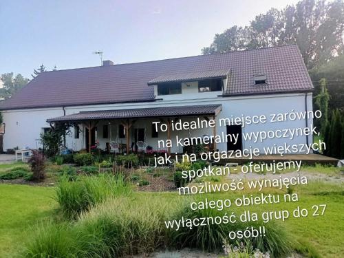 a house with a sign in front of it at Noclegi i sauna w starym domu in Pławnica