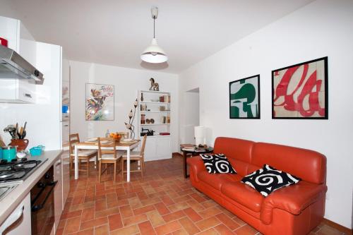 a living room with a red couch and a table at Residenza I Due Mondi in Spoleto