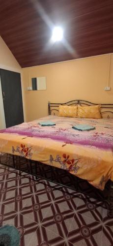 a bedroom with a large bed with a yellow blanket at The Green resort goa in Canacona