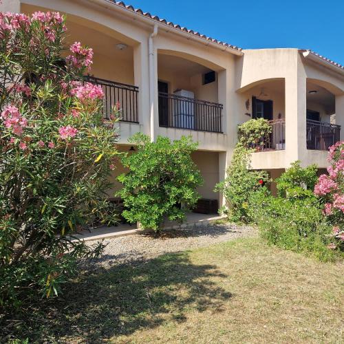 an apartment building with pink flowers in the yard at I Mucchi in Galeria