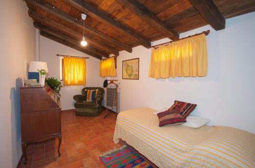 een slaapkamer met een bed en een stoel erin bij Residenza I Due Mondi in Spoleto