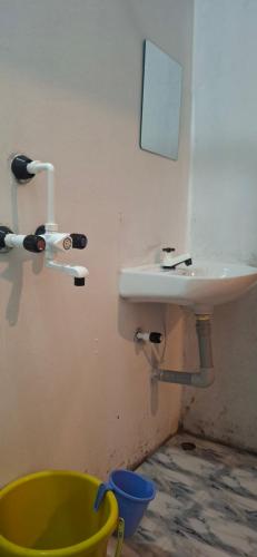 a bathroom with a sink and a yellow bucket at The Green resort goa in Canacona