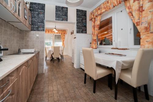 a kitchen and dining room with a table and chairs at Varga Vendégház in Tótszerdahely