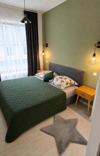 a bedroom with a green bed and a star rug at Apartmán na Rohu I in Malacky