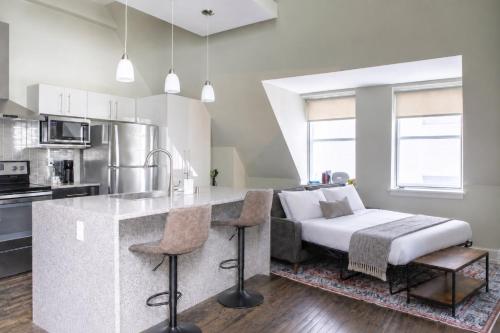 a kitchen with a kitchen island with a bed in it at Downtown Luxury 1BR Loft · Walkable · Sleeps 4 in Milwaukee