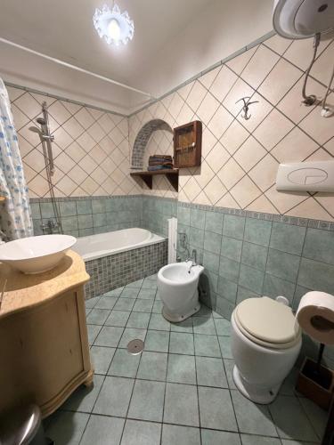 a bathroom with a toilet and a sink and a tub at villa Cycas in Maratea