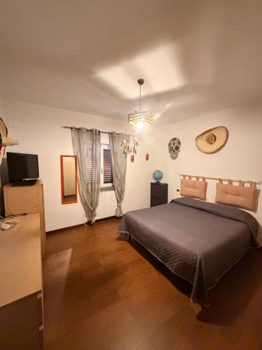 a bedroom with a bed and a television and a window at villa Cycas in Maratea
