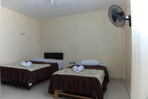a room with two beds with white towels on them at Hotel Inca Perú in Piura