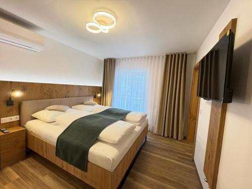 a bedroom with a large bed and a television at Apartmenthotel Rosentaler Hof Quartier2 in Pirk