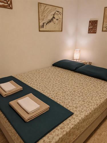 a bedroom with two beds with towels and a table at Apartman Dona in Petrovac na Moru