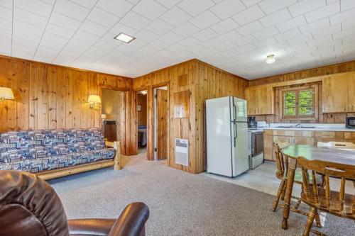a living room with a refrigerator and a table at Cabin #9 2BR 1BA Timberlane Resort in Park Rapids