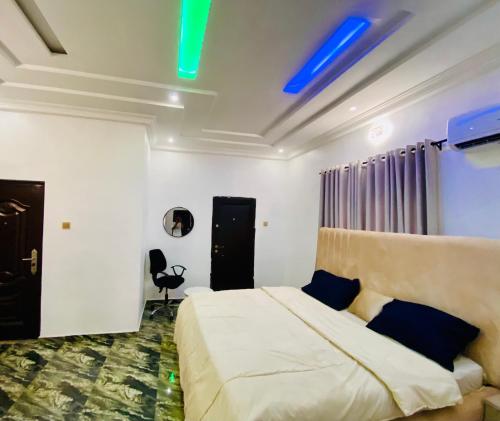 a bedroom with a bed with blue lights on the ceiling at Gustavó Premium Apartment in Benin City