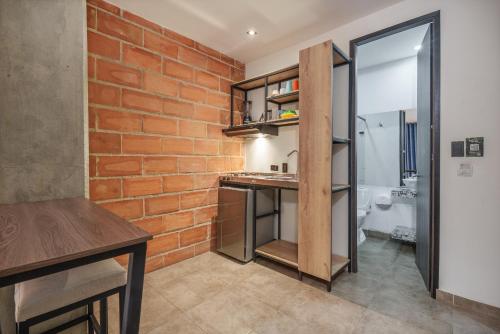 a kitchen with a brick wall and a counter in a room at Appartments Pool and Rooftop Downtown Hotel in Medellín