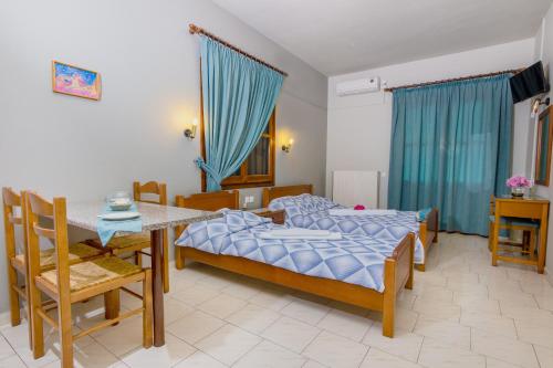 a bedroom with a bed and a table and chairs at Charoula in Platanias
