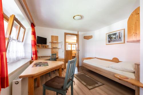 a bedroom with a bed and a table and a desk at Pension MÜLLER - ehemals Pension Wenger in Kirchheim im Innkreis