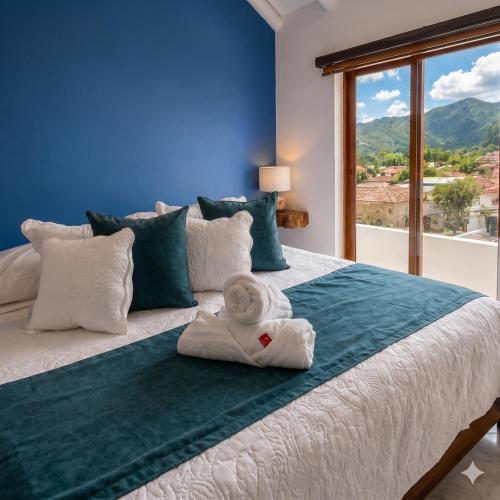a bedroom with a bed with a towel on it at Casa Hotel Cenit in Villa de Leyva