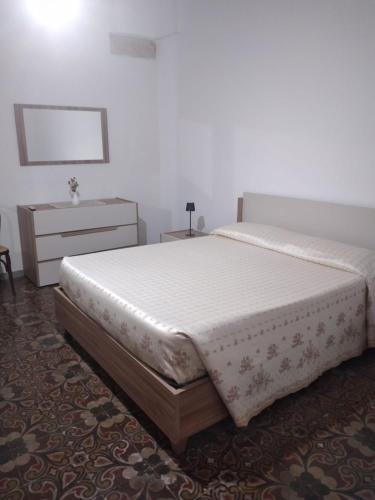 a bedroom with a large bed and a dresser at Casa Carolina in Surano