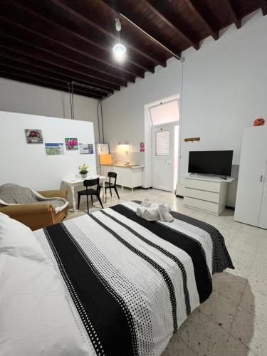 a bedroom with a large bed and a living room at Casa Vega-Marrero in Arucas