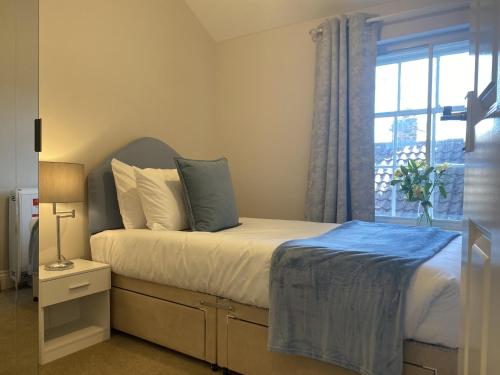 a bedroom with a bed with a window at Spa View Apartments in Ripon